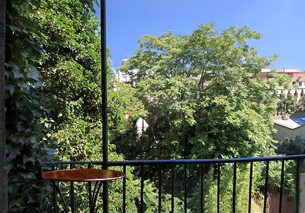 Le balcon-terrasse avec vue sur des jardins et de grands arbres